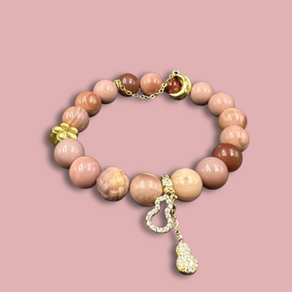 Baby Pink Agate Bracelet & 14k golden plated charms of flower, moon, and calabash - front view